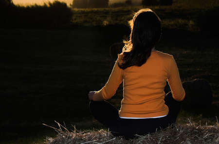 Woman seated in a hay baleの写真素材