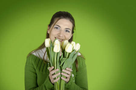 Beautiful woman with tulips on a green backgroundの写真素材