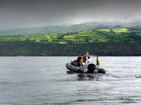 Small boat on the ocean observing dolphinsの写真素材