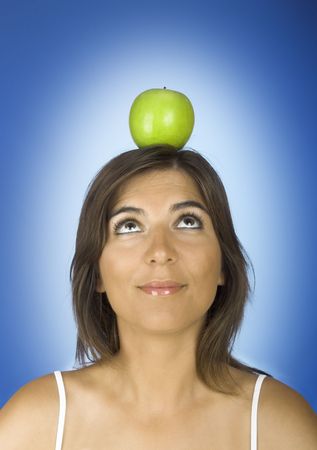 Portrait of a young woman with a apple on the headの写真素材