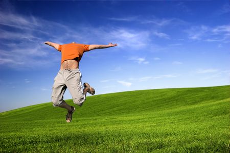 Man making a big jump on a beautiful green meadow