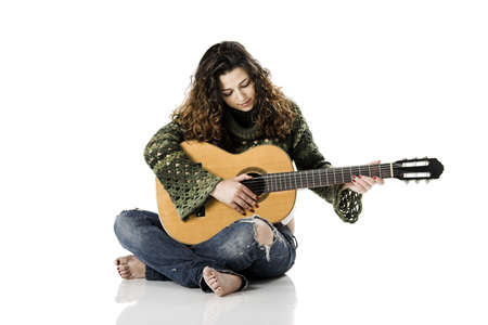 Beautiful woman isolated on white playing music with a guitarの写真素材