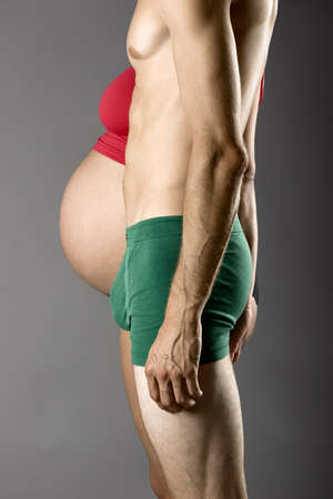 Pregnancy Concept - A nine months pregnant woman and a very skinny manの写真素材