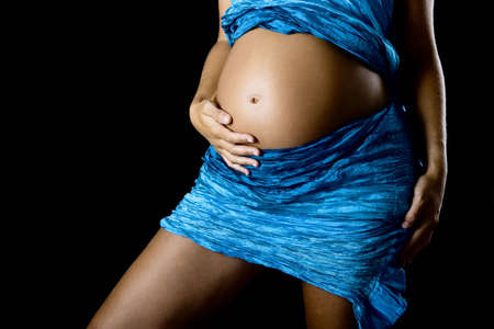 Beautiful pregant woman with her hand on the tummyの写真素材
