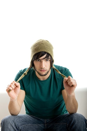 Good-looking young man seated on the couch isolated on whiteの写真素材