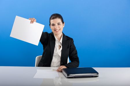 Businesswoman sitting in office showing something on a paperの写真素材