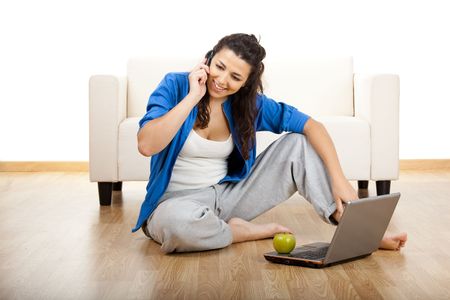 
Portrait of a girl seated on floor calling on phoneの写真素材