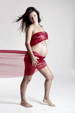 Beautiful pregnant woman posing over a gray backgroundの写真素材