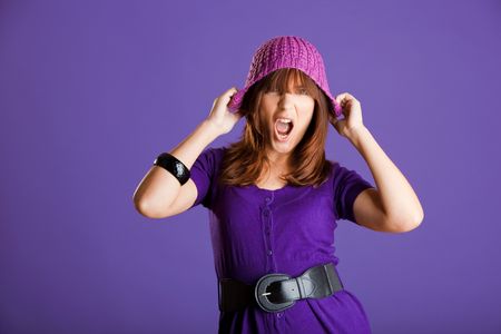 Portrait of a beautiful woman yelling, over a violet backgroundの写真素材