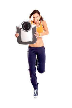 Beautiful athletic girl holding a scale and jumping, isolated on white
