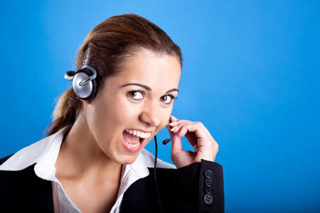 Portrait of a beautiful and young businesswoman with headsets and laughingの写真素材