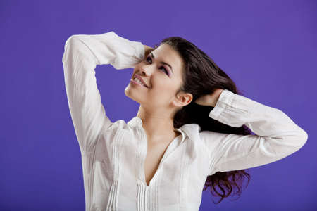 Studio portrait of a young beautiful woman posing on a purple backgroundの写真素材