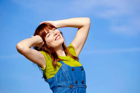 Portrait of a happy beautiful woman over a blue skyの写真素材