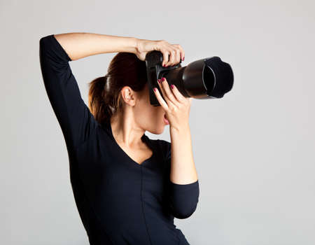 Portrait of a beautiful and attractive young woman holding a camera