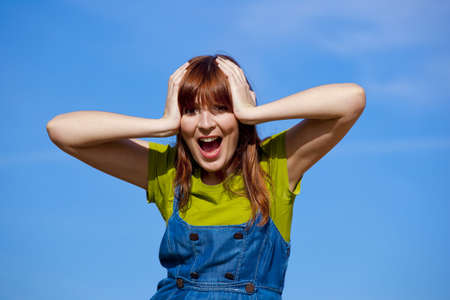 Portrait of a happy beautiful woman over a blue skyの写真素材