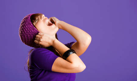 Portrait of a beautiful woman yelling, over a violet backgroundの写真素材