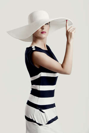 Portrait of a beautiful fashion woman posing with a hat