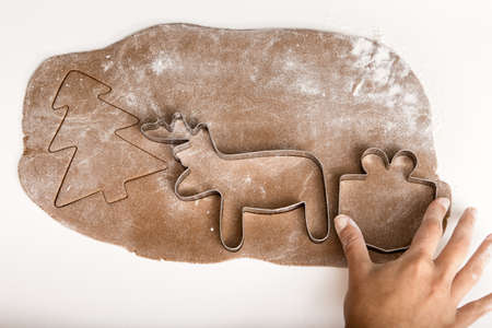 Woman holding a homemade Gingerbread cookie with a shape of a Christmas treeの写真素材