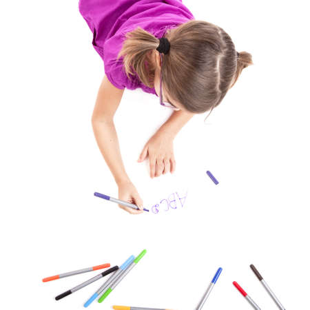 Girl lying on floor and making drawings on paperの写真素材