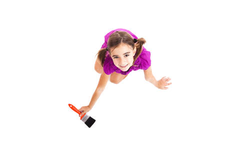 Top view of a happy girl sitting on floor holding a paint-brushの写真素材