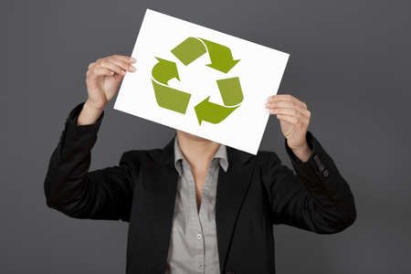 Woman holding a sheet of paper with the recycling symbolの写真素材