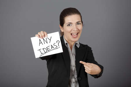 Business woman holding a card board with the text message "Hire me", focus is on the cardboardの写真素材