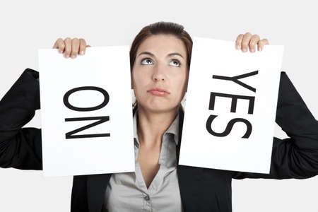 Business young woman trying to make a decision between Yes or No choiceの写真素材