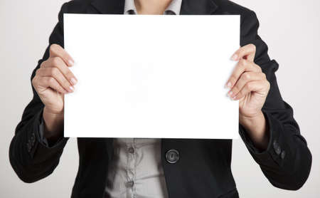 Woman holding a blank paper sheet with both handsの写真素材