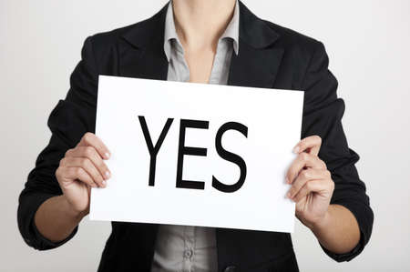 Business woman holding a paper card with the word YESの写真素材