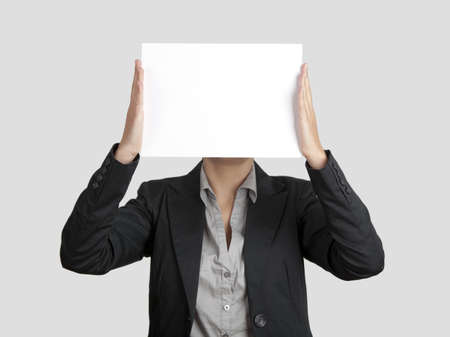 Woman showing a blank paper sheet in front of her head
の写真素材