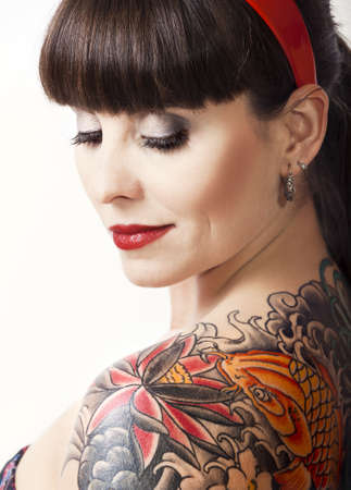 Portrait of a beautiful young woman with a tattoo on the backsの写真素材