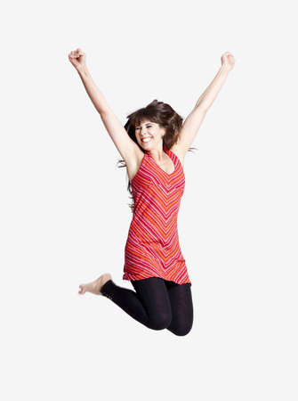 Beautiful happy woman jumping over a grey background Beautiful happy woman jumping over a grey background