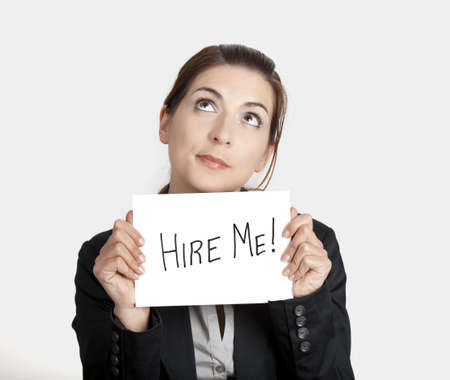 Business woman holding a card board with the text message "Hire me"の写真素材