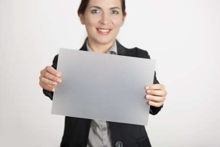 Beautiful business woman holding a blank translucid paper sheetの写真素材