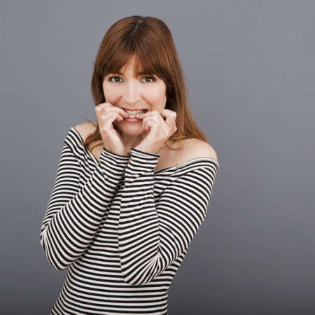 Portrait of a stressed young woman biting nailsの写真素材