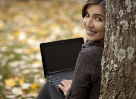 Beautiful woman working with a laptop in outdoorの写真素材