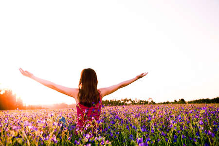 Free girl enjoying the nature on a beautiful flowery fieldの写真素材