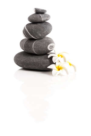 Stones pyramid with a plumeria flower, isolated on white backgroundの写真素材