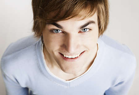 Portrait of a handsome young man looking up and laughing