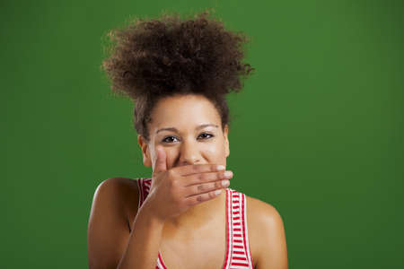 Beautiful African woman laughing over a green background