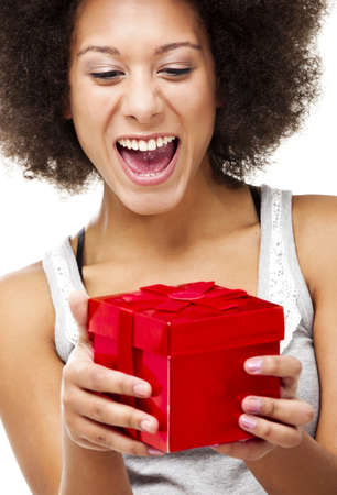Beautiful happy young woman holding a red christmas gift, isolated on white