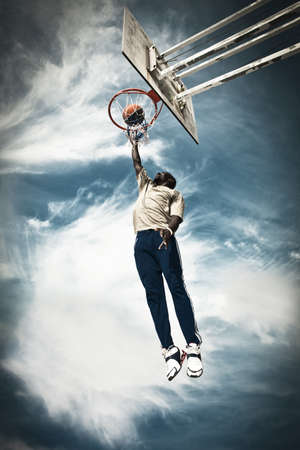 A basketball player drives to the hoop for a slam 