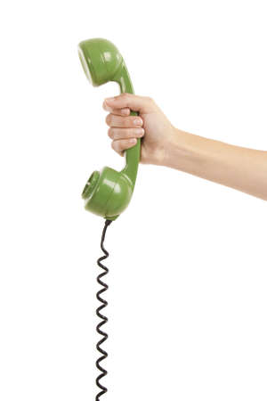 Female hand holding a green handpiece from a vintage telephoneの写真素材