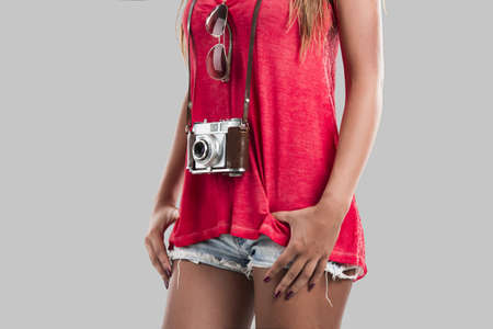 Beautiful young woman posing with a old vintage camera
