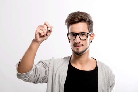 Portrait of a handsome young man wearing glasses and  writting something on a glass writeboardの写真素材