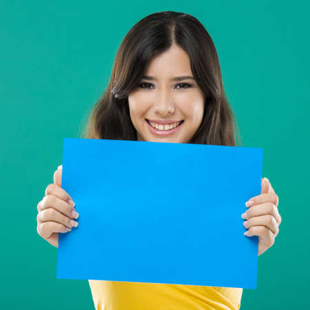 Beautiful asian woman holding a blue billboard, over a green backgroundの写真素材