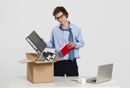 Young man in the office packing up after being fired