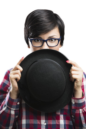 Beautiful girl with a funny face wearing a hat and nerd glasses, isolated over white backgroundの写真素材
