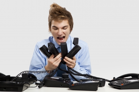 Young man holding and yelling to the phonesの写真素材