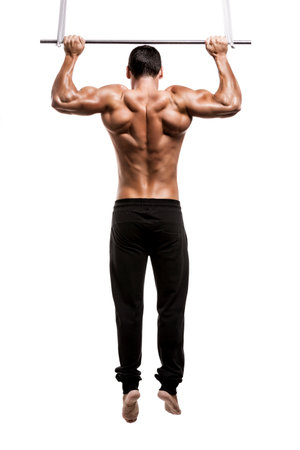 Muscle man in studio making elevations, isolated over a white background
